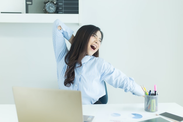 La giovane donna asiatica felice di affari ha finito il suo lavoro nel luogo di lavoro.