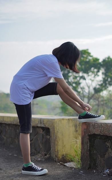 La giovane donna asiatica ha preparato le sue scarpe prima di correre e fare jogging al mattino