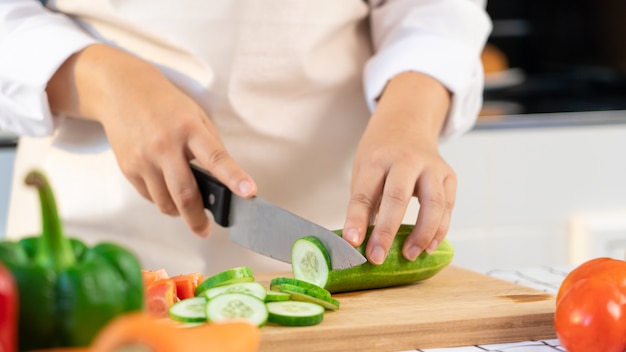 La giovane donna asiatica sta preparando insalata di verdure dell'alimento sano