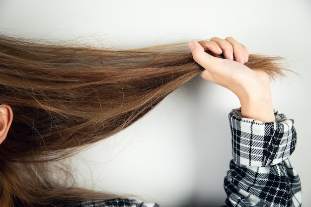 La giovane donna attraente che tira i suoi capelli.