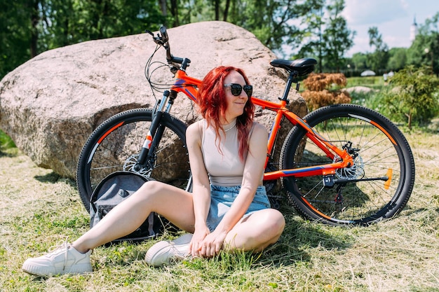 La giovane donna attraente sta riposando dopo il giro in bicicletta Sport di stile di vita attivo