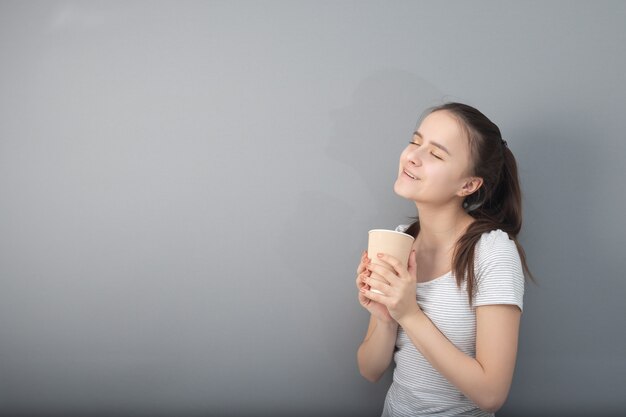 La giovane donna beve il caffè aromatico in tazza