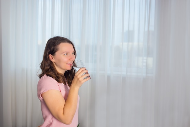 la giovane donna beve l'acqua da un bicchiere