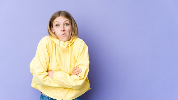 La giovane donna bionda scrolla le spalle le spalle