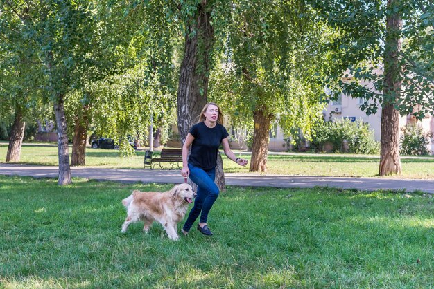 La giovane donna cammina con il suo documentalista nel parco all'aperto.