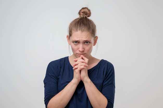 La giovane donna caucasica con il nodo è triste a causa di qualcosa.