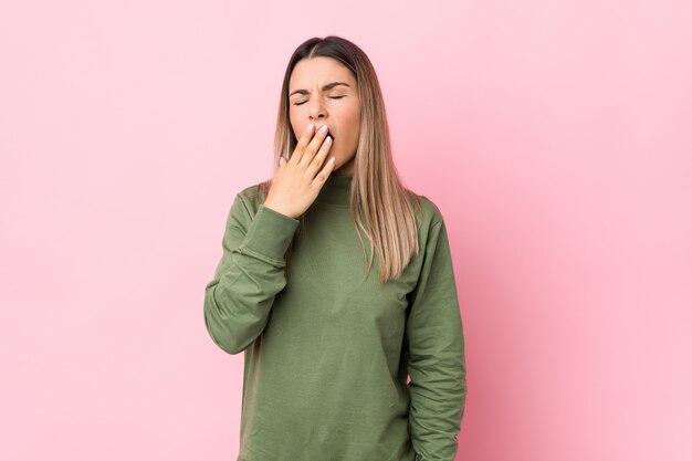 La giovane donna caucasica ha isolato lo sbadiglio mostrando un gesto stanco che copre la bocca di mano.