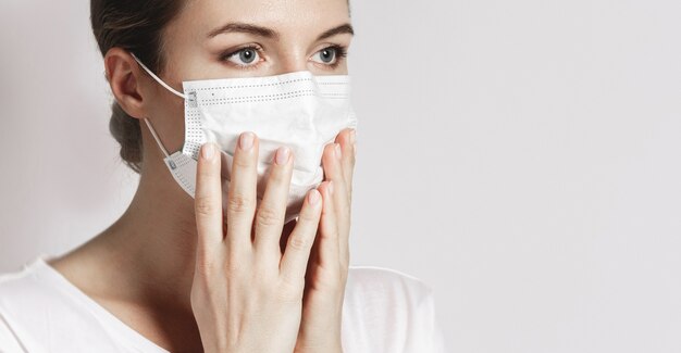 La giovane donna caucasica indossa una maschera facciale per proteggersi dai virus