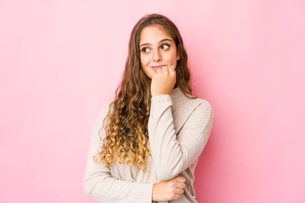 La giovane donna caucasica si è rilassata pensando a qualcosa guardando uno spazio di copia.