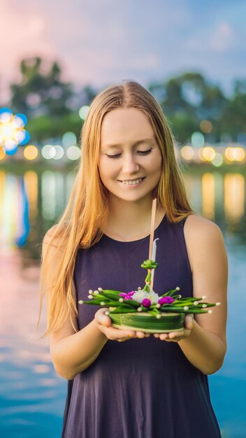 La giovane donna celebra loy krathong corre sull'acqua loy krathong festival la gente compra fiori e