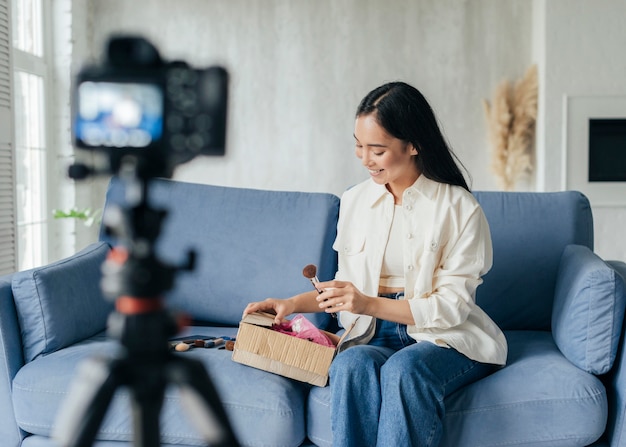 La giovane donna che le mostra compone i rifornimenti mentre vlog