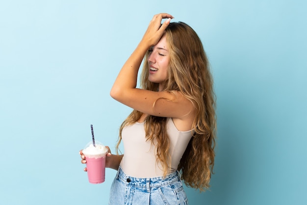 La giovane donna con il frappè alla fragola isolato sull'azzurro ha realizzato qualcosa e intende la soluzione