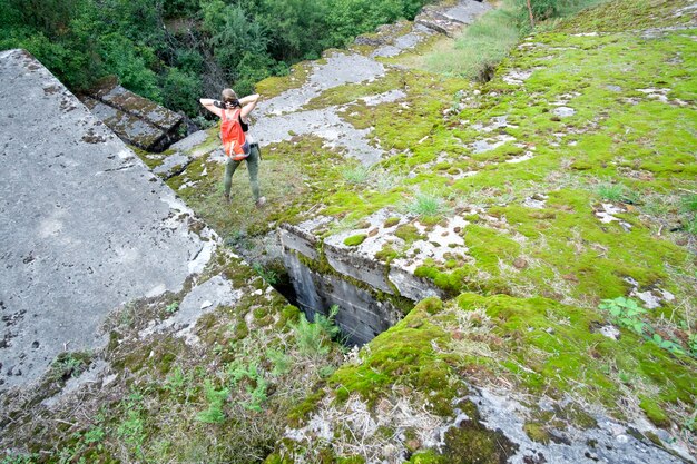 La giovane donna con lo zaino arancio di viaggio esplora la fortezza antica