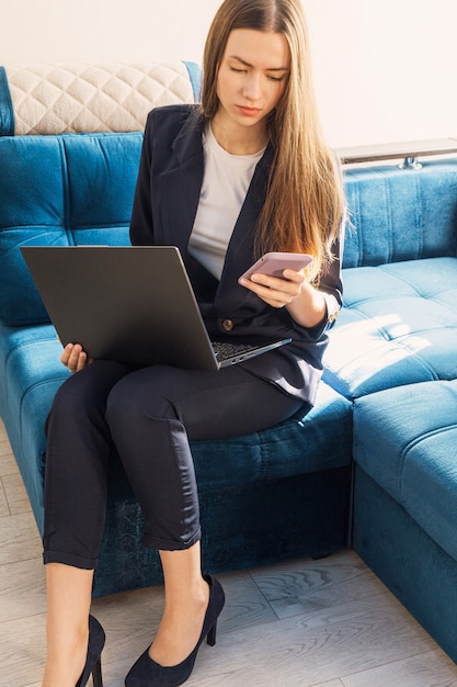 La giovane donna con un taccuino sta studiando o lavorando a casa e sta chiamando al telefono