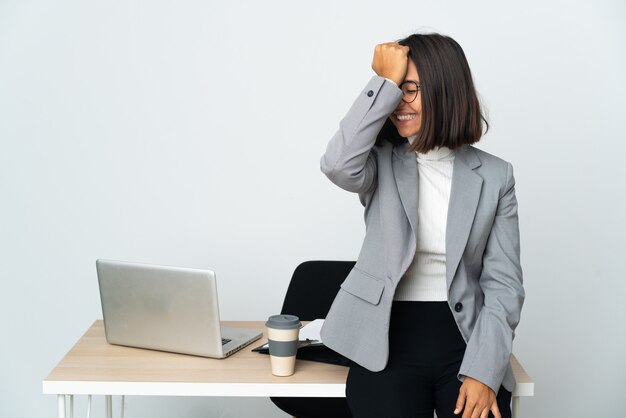 La giovane donna d'affari latina che lavora in un ufficio isolato sul muro bianco ha realizzato qualcosa e intende la soluzione