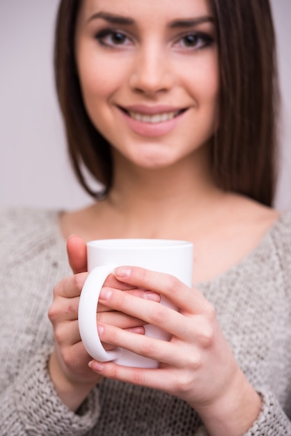 La giovane donna del primo piano sta tenendo una tazza di tè.