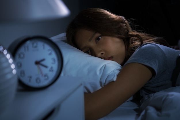 La giovane donna depressa sdraiata a letto non riesce a dormire per l'insonnia