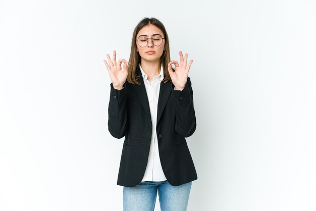 La giovane donna di affari si rilassa dopo una dura giornata di lavoro, sta eseguendo yoga