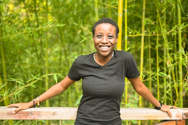 La giovane donna di colore africana dai capelli corti di bellezza naturale sorridente felice attraente che ride si appoggia su a