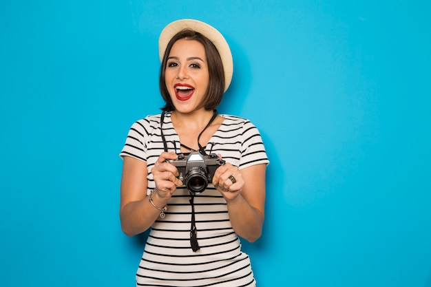 La giovane donna di modo fa la foto con la vecchia macchina fotografica