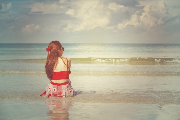 La giovane donna di modo si distende sulla spiaggia