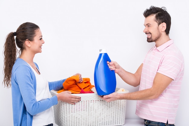 La giovane donna e l'uomo stanno facendo il bucato a casa.