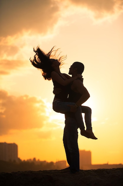 La giovane donna è saltata su un fidanzato contro il cielo al tramonto