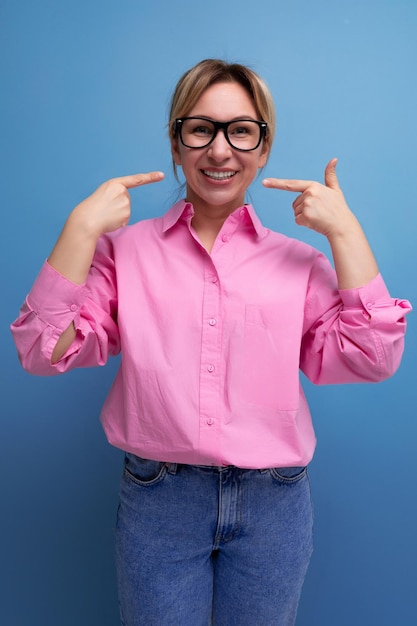 La giovane donna europea attraente dell'impiegato vestita in una camicia rosa dimostra la fiducia dentro