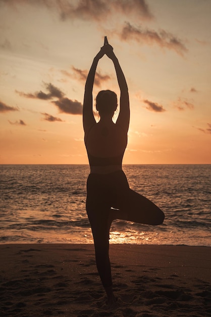 La giovane donna fa yoga per uno stile di vita sano sulla spiaggia del mare