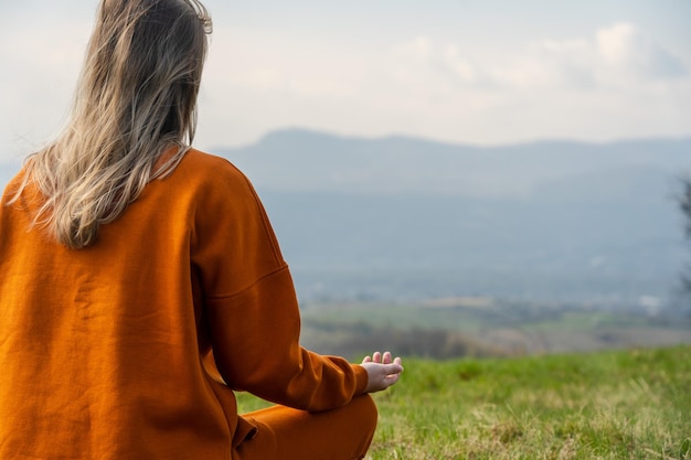 La giovane donna fa yoga sulla meditazione di montagna