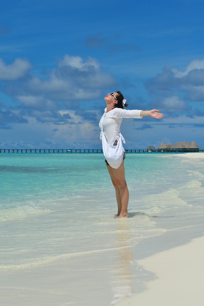 la giovane donna felice in vacanza estiva sulla bellissima spiaggia tropicale si diverte e si rilassa