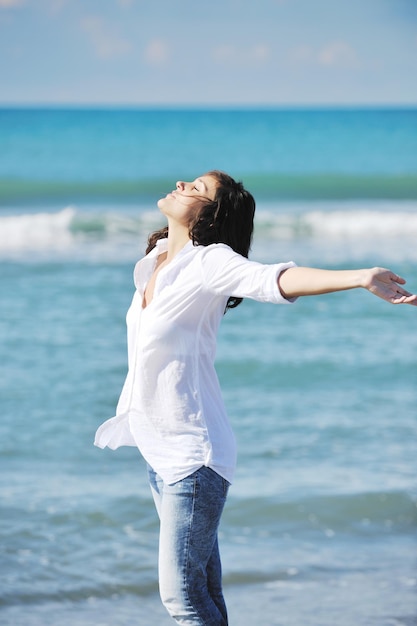 la giovane donna felice si rilassa sulla bellissima spiaggia al mattino