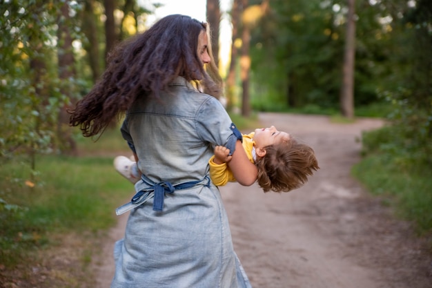 La giovane donna gioca con la bambina in giallo nel parco