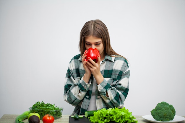 La giovane donna graziosa aderisce alla dieta e tiene le verdure