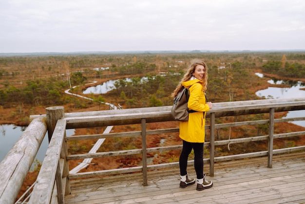 La giovane donna guarda la natura straordinaria sul ponte di osservazione Il turista gode di una vista di paludi magiche