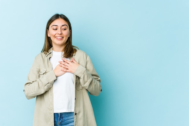 La giovane donna ha un'espressione amichevole, premendo il palmo sul petto