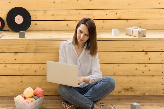 La giovane donna impara a lavorare a maglia La donna sta imparando a lavorare a maglia durante le video lezioni