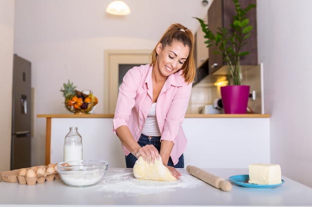 La giovane donna impasta la pasta alla cucina