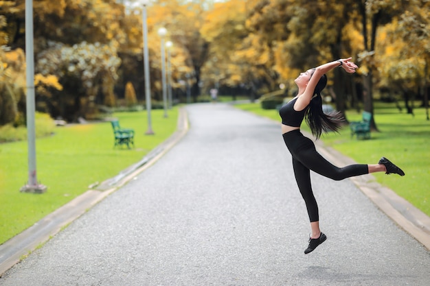 La giovane donna in buona salute e sportiva fa l'allungamento di yoga all'aperto