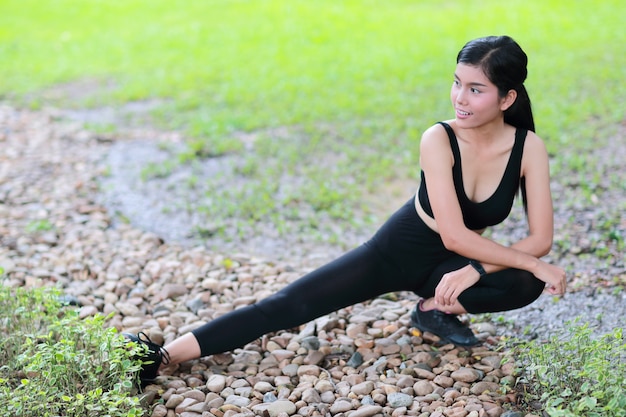 La giovane donna in buona salute e sportiva fa l&#39;allungamento di yoga all&#39;aperto