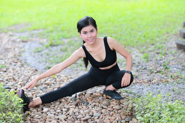La giovane donna in buona salute e sportiva fa l&#39;allungamento di yoga all&#39;aperto