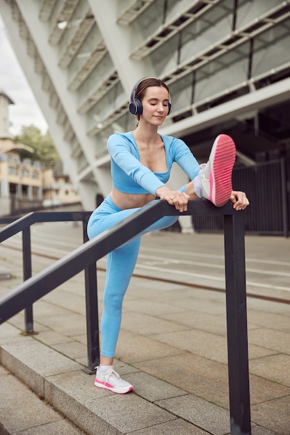 La giovane donna in forma sta facendo fitness e fa jogging in un luogo urbano