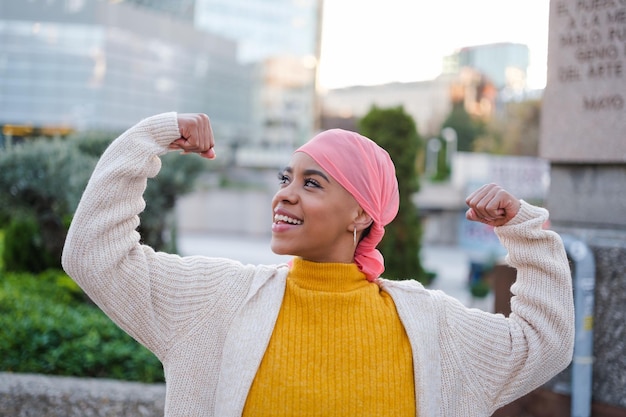 La giovane donna in sciarpa rosa combatte la malattia del cancro e si sente forte per superarla Concetto di malattia lotta all'assistenza sanitaria