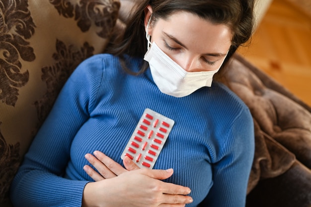 La giovane donna in una fasciatura prende le pillole