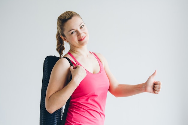 La giovane donna in una stanza bianca venne allo yoga