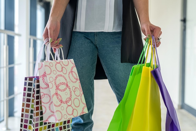 la giovane donna indossa un panno elegante con le borse della spesa al centro commerciale, venerdì nero. saldi e sconti