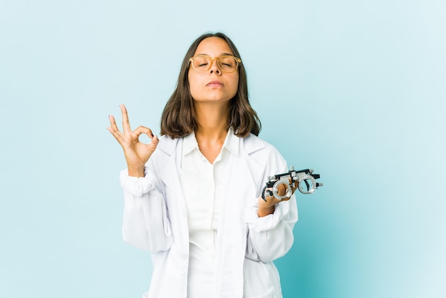 La giovane donna latina oculista si rilassa dopo una dura giornata di lavoro, sta eseguendo yoga.