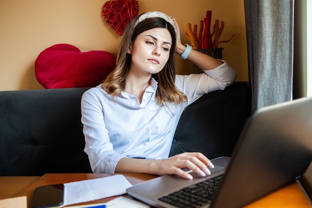 La giovane donna lavora al computer in un bar