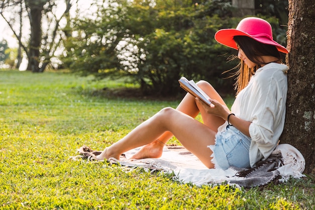 La giovane donna legge nel parco