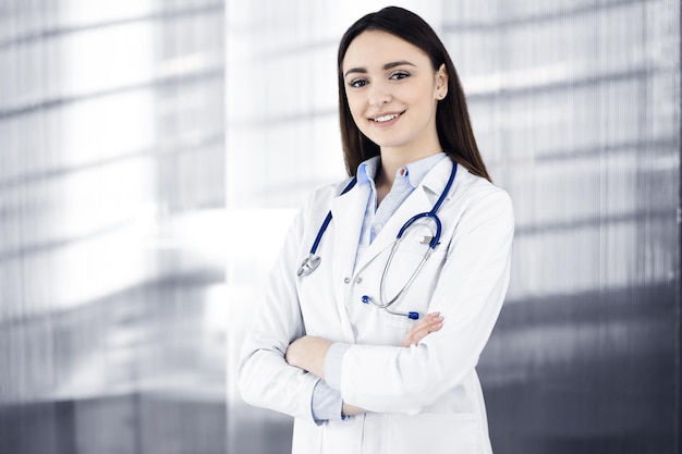 La giovane donna-medico sorridente sta riempiendo le raccomandazioni mediche usando una lavagna per appunti. Terapista al lavoro in uno studio clinico. Concetto di medicina.